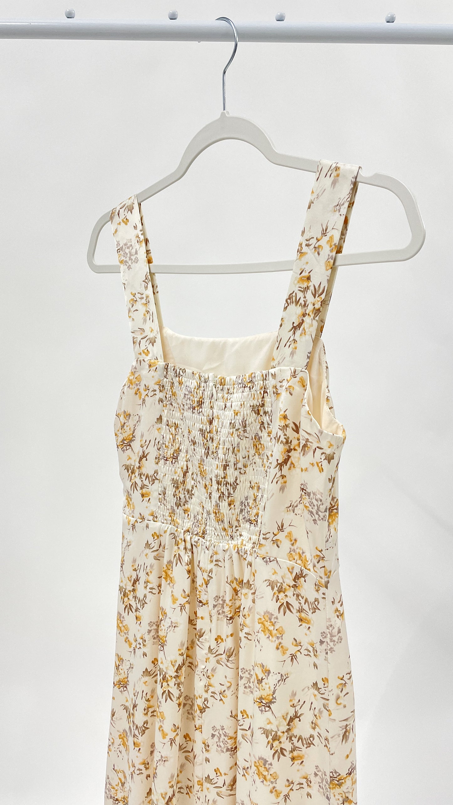 Beautiful ivory square neck midi dress with twist tie and elegant ruffle detail. Smocked back detail with zipper closure.