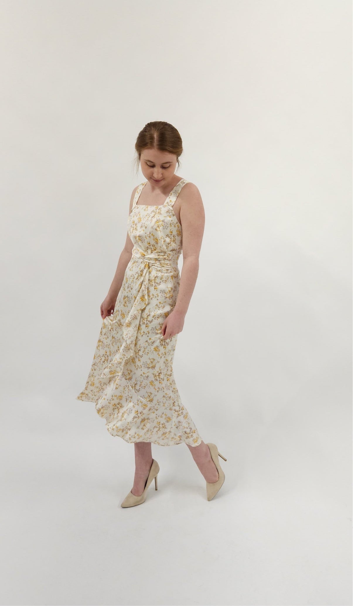 Beautiful ivory square neck midi dress with twist tie and elegant ruffle detail. Smocked back detail with zipper closure.