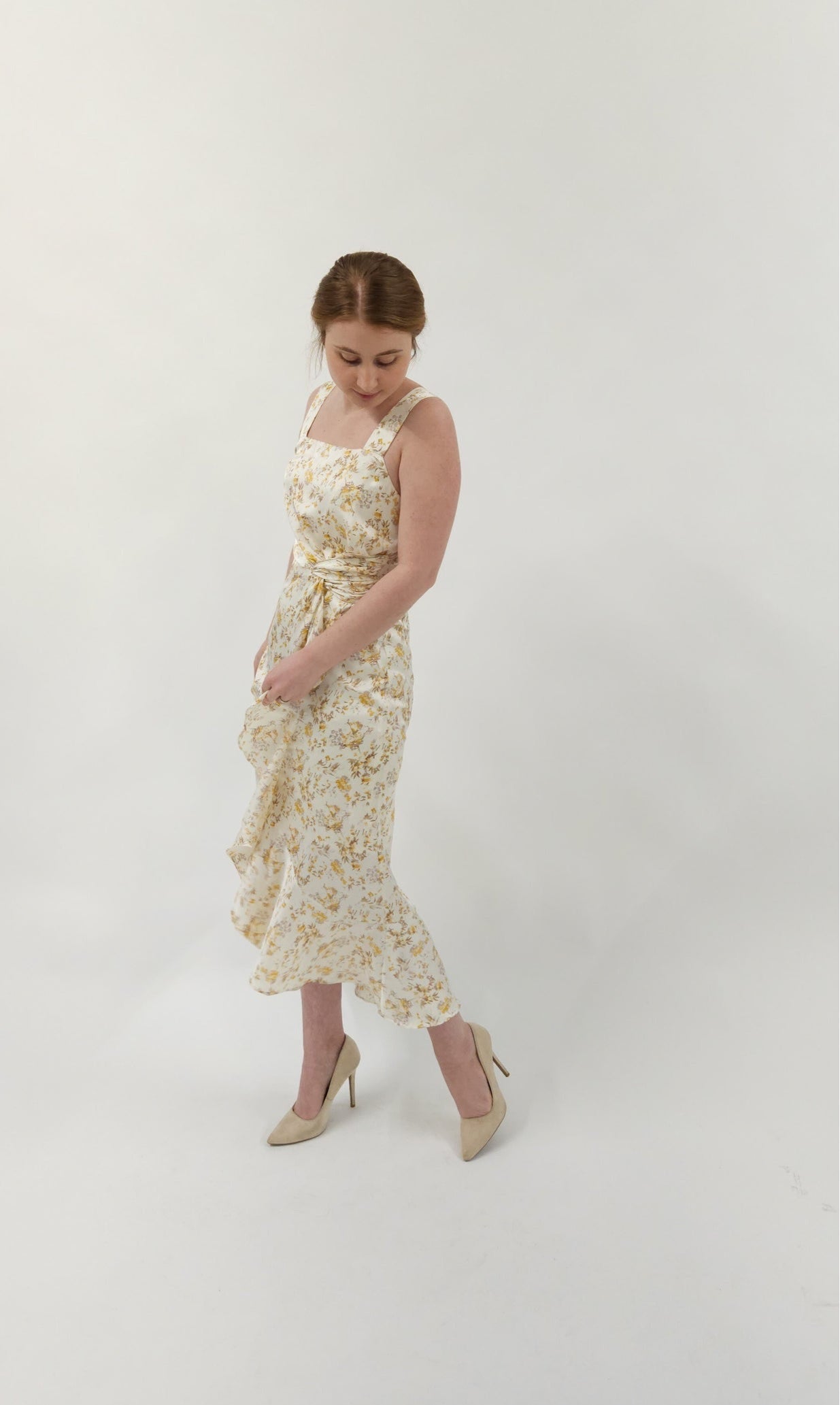 Beautiful ivory square neck midi dress with twist tie and elegant ruffle detail. Smocked back detail with zipper closure.
