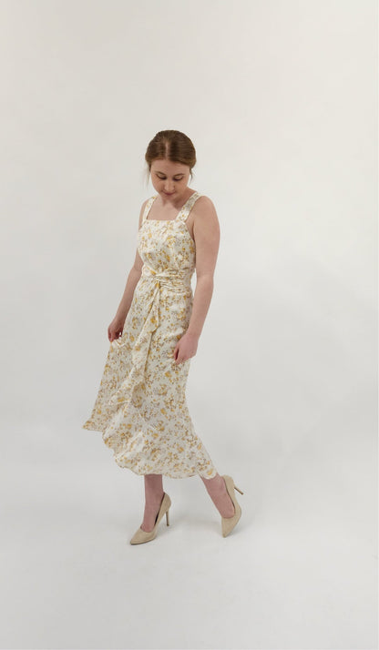 Beautiful ivory square neck midi dress with twist tie and elegant ruffle detail. Smocked back detail with zipper closure. 