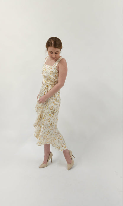 Beautiful ivory square neck midi dress with twist tie and elegant ruffle detail. Smocked back detail with zipper closure. 